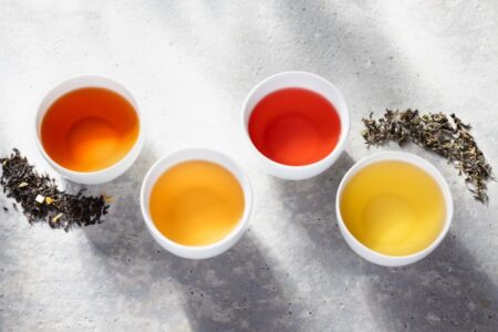 Four cups of tea on a grey table